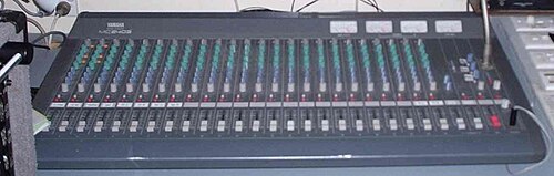 Yamaha 2403 audio mixing console (or "board") in a "live" mixing application. Each column of knobs controls the volume, tone, and other elements for a single channel (e.g. a microphone being used by a singer).