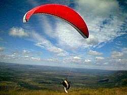 A paraglider taking off in Brazil