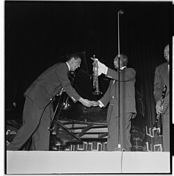 Young, left, shaking hands with Louis Armstrong at a 1955 concert in Oslo