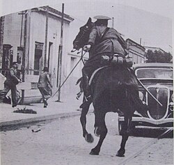 A mounted police officer chases supporters of radicalism.