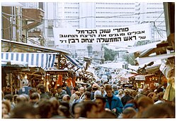 A poster mourning the assassination of Yitzhak Rabin hangs in the Carmel Market in Tel Aviv, 1995