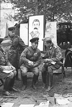 German and Soviet soldiers during the official transfer of Brest to Soviet control in front of picture of Stalin, in the aftermath of the invasion and partition of Poland by Nazi Germany and the Soviet Union in 1939