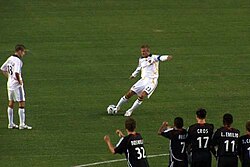 Beckham scoring with a bending free kick in 2007. His typical pose when striking free kicks or crossing the ball in open play, his body leans to the left to generate extra whip on the ball.