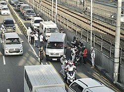 Traffic enforcers in Manila, Philippines, ticketing unauthorized vehicles using the EDSA Busway.