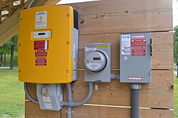 String inverter (left), generation meter, and AC disconnect (right). A modern 2013 installation in Vermont, United States.