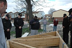 Antonio Burke, pastor for the Center of Love Church of God in Christ (COGIC), leads Sailors from amphibious transport dock USS Nashville (LPD-13) in a prayer before building a house for Habitat for Humanity in Norfolk, Va.