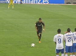 A player taking a direct free kick; free kicks are often struck using curl or minimal-spin techniques.