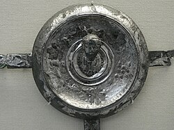 One of the Xanten Horse-Phalerae located in the British Museum, measuring 10.5 cm (4.1 in).[10] It bears an inscription formed from punched dots: PLINIO PRAEF EQ; i.e., Plinio praefecto equitum, "Pliny prefect of cavalry". It was perhaps issued to every man in Pliny's unit. The figure is the bust of the emperor.