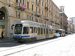 A city tram. A bus can be seen behind.