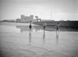 Walter Mittelholzer's traveling companions playing ball on the beach of Cape Juby, image between 1930 and 1931.