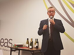 Gove speaking into a microphone at an indoor event