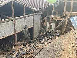 Japan Self-Defense Forces (JSDF) personnel inspecting a collapsed house