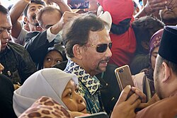 Hassanal Bolkiah on his 2023 visit to the Belait District, seen greeting the populace[87]