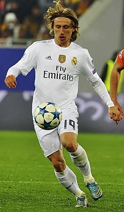 Real Madrid's jersey (worn by Luka Modrić in 2015) is manufactured by Adidas, with Emirates the shirt sponsor.