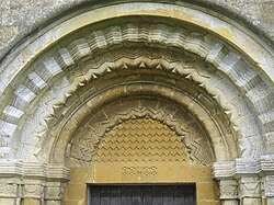 A Norman arch and tympanum with zig-zag mouldings above the church doorway at Guiting Power, Gloucestershire