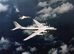 An F-8J of Oriskany intercepts a Tu-95 'Bear-B', 1974.