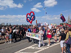Polyamorous people parading under their banner and staff at Antwerp Pride 2025.