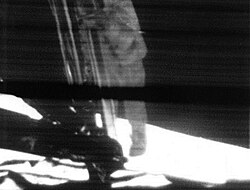 Neil Armstrong descends the LM's ladder in preparation for the first steps on the lunar surface, as televised live on July 20, 1969.