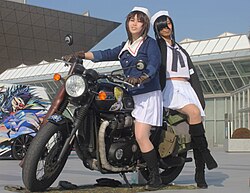 Women cosplaying as characters from Girls und Panzer in the itasha exhibition area during a fanzine sales event at Tokyo Big Sight.