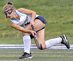 An American high school field hockey player wearing goggles and a mouthguard