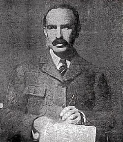 Soper, wearing a jacket and tie