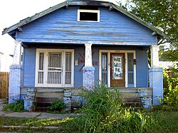 Blue house on N. Robertson St., Upper 9th Ward. The door reads, "We will be back."
