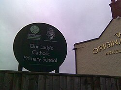 A sign for a Catholic school in Oxford, with the coat-of-arms of the Archdiocese of Birmingham and the logo of the Oxfordshire County Council.