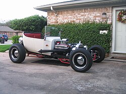 A 1923 Ford T-bucket in the traditional style with lake headers, dog dish hubcaps, dropped "I" beam axle, narrow rubber, and single 4-barrel, but non-traditional disc brakes