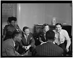 From left to right: Mary Lou Williams, Tadd Dameron, Milt Orent, Dixie Bailey, Dizzy Gillespie, and Jack Teagarden. Mary Lou Williams' apartment, New York, N.Y., ca. Aug. 1947 (LOC) (5475990477)