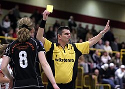 Yellow card shown in a handball match