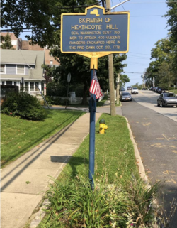 Typical mid-20th century official New York State Historical Marker for a minor battlefield, free standing on a suburban street