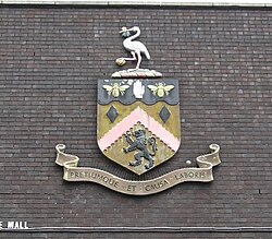 The coat of arms of Burnley with an inscription on the bottom reading "Pretiumque et causa laboris"