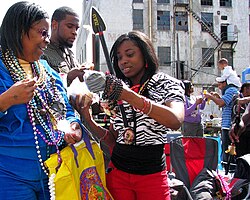 Revelers on Basin Street examine their parade catches, including a Zulu Coconut, 2009