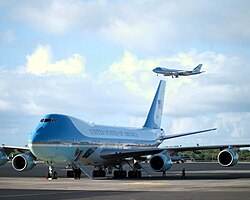 SAM 28000 sits on the ramp as SAM 29000 descends on final approach to Hickam Field with President George W. Bush.