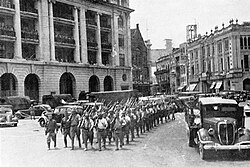 Victorious Japanese troops marching through the city center of Singapore following the city's capture in February 1942