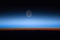 Horizon and layers of the atmosphere as seen from NASA Earth Observatory: troposphere (darkest), tropopause (brown), stratosphere (gray), mesosphere, thermosphere, and exosphere (blues). Colors are due to the dominant gases and particles in each layer.