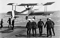 Squadron Commander E. H. Dunning attempting to land his Sopwith Pup on the flying-off deck of HMS Furious, Scapa Flow, 7 August 1917. He was killed on another attempt later that day when his aircraft veered off the flight deck and into the sea.