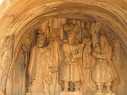 Investiture scene: Anahita on the left as the patron yazata of the Sasanian dynasty behind Emperor Khosrow II, with Ahura Mazda presenting the khvarenah of sovereignty on the right. Taq-e Bostan, Iran