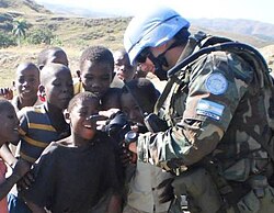 Soldier of the Argentine Joint Battalion of MINUSTAH entertains some children.