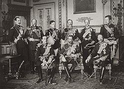 The Nine Sovereigns at Windsor for the funeral of King Edward VII, photographed on 20 May 1910. Standing, from left to right: Haakon VII of Norway, Ferdinand I of Bulgaria, Manuel II of Portugal, Wilhelm II of Germany, George I of Greece and Albert I of Belgium. Seated, from left to right: Alfonso XIII of Spain, George V of the United Kingdom and Frederick VIII of Denmark.