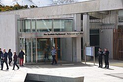 Bilingual signage above an entrance to the Scottish Parliament Building