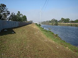 A portion of the 17th Street Canal, looking lakeward from behind the Metarie Road Pumping Station. Note the levees topped with concrete flood walls.