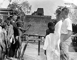 Maroons being taught in the outdoors, 1943. At the top of the blackboard is Santa Teresia begi foe wi, 'Saint Teresa, pray for us' in Sranan Tongo.