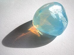Rayleigh scattering in opalescent glass: it appears blue from the side, but orange light shines through.[22]