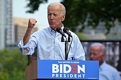 Photo of Biden raising his fist while standing behind a lectern