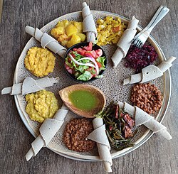This meal consisting of injera and several kinds of wat ('stew'), is typical of Ethiopian cuisine.