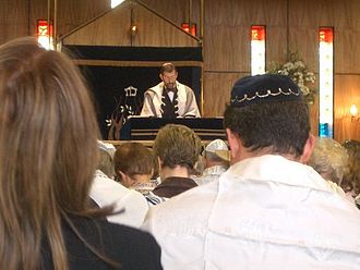 Contemporary Reform service held in Sinai Synagogue, with some congregants wearing head coverings and prayer shawls.