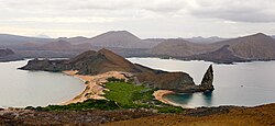 Pinnacle Rock on Bartolomé Island, with Santiago in the background and a ferry on the right for scale