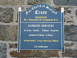 A sign indicating services in Gaelic and English at a Free Church of Scotland congregation in the community of Ness, Isle of Lewis