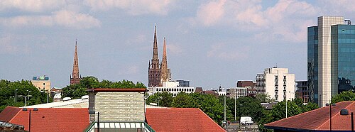 Coventry's skyline (view from the footbridge over the railway by Central 6 shopping centre). The three spires are: Holy Trinity (left), remaining spire of the ruined (bombed) cathedral and the remaining spire of the ruined Christ Church (right)